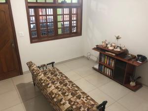 a living room with a couch and a book shelf at HOSTEL DO PAPAI 2 in Lavras