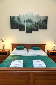 a bedroom with a bed with four paintings on the wall at Apartament Żychoniówka in Zakopane