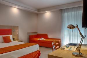 a hotel room with a bed and a chair and a desk at American Hotel in Pozzuoli +65 photos