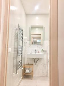 bagno bianco con lavandino e specchio di Sunset rooms a La Spezia