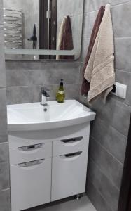 W łazience znajduje się biała umywalka i lustro. w obiekcie Однокомнатная квартира по проспекту Коцюбинского w mieście Winnica