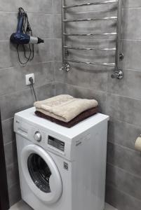 pralka z ręcznikiem na górze w łazience w obiekcie Однокомнатная квартира по проспекту Коцюбинского w mieście Winnica