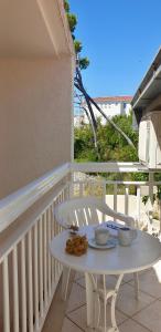 a white table and a white chair on a balcony at Vila Jela in Baška Voda