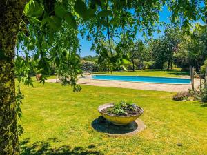 - un grand bol dans l'herbe à côté de la piscine dans l'établissement La Grange aux Moines, à Berthenay