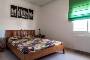 a bedroom with a bed with a quilt on it at CASA CON JARDIN-WIFI FREE in L'Escala