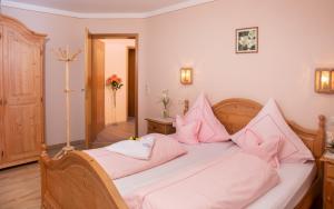 a bedroom with a large bed with pink pillows at Ferienwohnung Cornelia in Bad Birnbach +27 photos