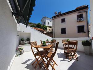 a patio with wooden tables and chairs on a balcony at Amarru Apartments in Piran