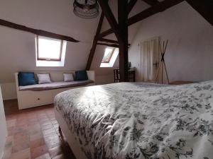 une chambre avec un lit et un canapé dans une pièce dans l'établissement Au bout du chemin, à Châteauvieux