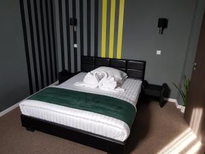 a bedroom with a bed with two pillows on it at Resita Residence Sauna Apartment in Reşiţa