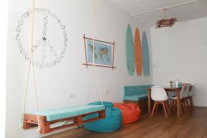 a room with two swing chairs and a table at Douro Surf Hostel in Vila Nova de Gaia