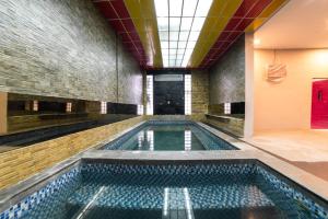 a swimming pool in a building with a ceiling at Glamour Hotel and Spa in Medan