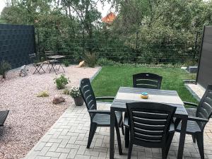 eine Terrasse mit einem Tisch und Stühlen im Hinterhof in der Unterkunft Modernes Ferienhaus an der Kapelle in Emsbüren