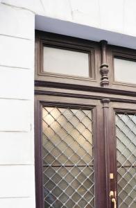 eine Holztür mit Glasfenstern auf einem Gebäude in der Unterkunft Ciro [Piazza Unità Italia] in Triest