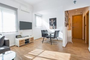 a living room with a table and chairs and a television at Apartment central Gandia in Gandía