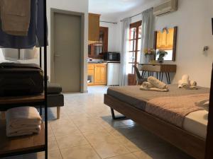 a bedroom with a large bed and a kitchen at Armonia Guest House Skiathos C in Skiathos