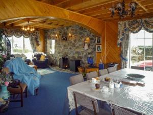 ein Wohnzimmer mit einem Tisch und einer Steinmauer in der Unterkunft Ballyheigue Guesthouse in Heirhill