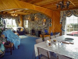 a living room with a table and a stone wall at Ballyheigue Guesthouse in Heirhill