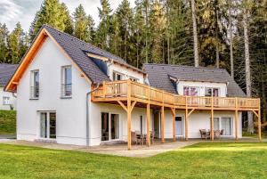 a house with a large deck on the front of it at Lipno Club in Frymburk