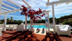 a gazebo with a bunch of red flowers on it at Villaggio Camping Oasi in Vieste