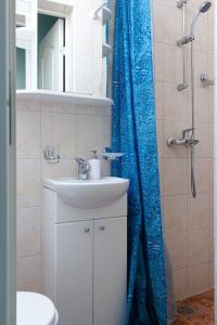 a bathroom with a sink and a blue shower curtain at Guest house Rasa in Palanga