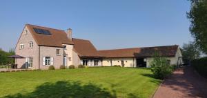 une grande maison avec une grande pelouse devant elle dans l'établissement B&B Bready, à Assenede