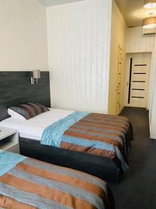 a hotel room with two beds in a room at Status Hotel in Poltava