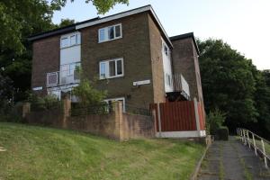 a brick house with a fence in front of it at Green Hill Apartment in Sheffield