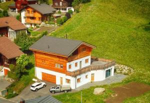 a house on a hill with cars parked in front of it at Brunnematta in Ernen