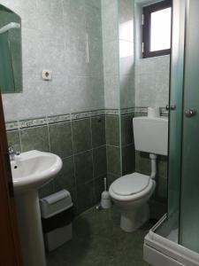 a bathroom with a toilet and a sink at Villa Geros in Trpejca