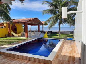 uma piscina numa villa com vista para o oceano em Casa à beira-mar, piscina em Pitimbu