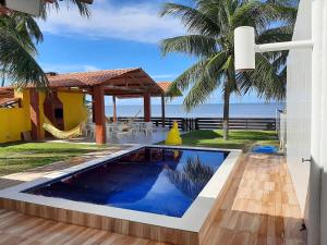 a swimming pool in a villa with a view of the ocean at Casa à beira-mar, piscina in Pitimbu