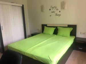 ラブダにあるRich IIのベッドルーム1室(ベッド1台、緑の掛け布団付)