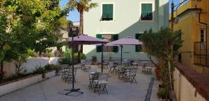 un patio avec des tables et des chaises et des parasols violets dans l'établissement Il Giardino dei Limoni Room & Apartments, à Gênes
