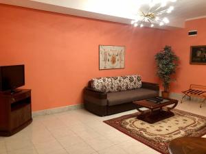 ein Wohnzimmer mit einem Sofa und einem TV in der Unterkunft Giuseppe Hotel in Kasan