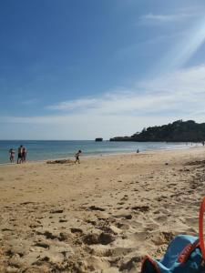 a group of people walking on the beach at Mira Parque in Albufeira