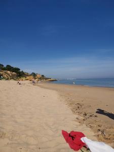 a red kite laying on a sandy beach at Mira Parque in Albufeira