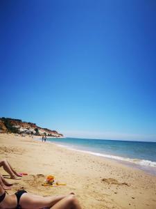 a group of people laying on the beach at Mira Parque in Albufeira