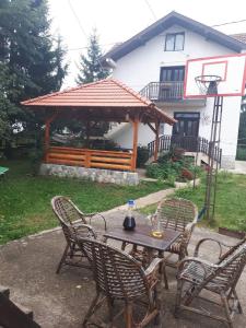 ズラティボールにあるZlatiborska seoska idilaの庭園内のガゼボ付きテーブルと椅子