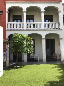 班約萊斯的住宿－El Llimoner，带阳台的白色建筑和绿色草坪