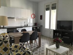 a kitchen with a table and chairs and a television at El Llimoner in Banyoles