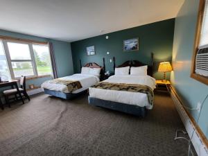 twee bedden in een kamer met groene muren bij Highland Motel in North Sydney