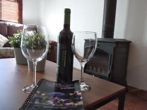 a bottle of wine and two wine glasses on a table at El Huerto de Pipo in Navarredonda de Gredos +9 photos