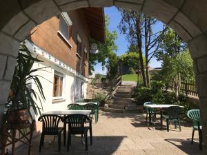 une arche avec des tables et des chaises à côté d'un bâtiment dans l'établissement Pension Jägerheim, à Krumbach