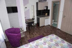 ヤブロネツ・ナド・ニソウにあるApartmány Freesiaの紫色のベッドと紫色の椅子が備わる客室です。
