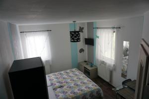 a small bedroom with a bed and two windows at Apartmány Freesia in Jablonec nad Nisou