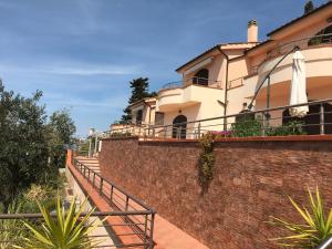 a building on a brick wall with stairs in front at Appartamento Alfea in Porto Santo Stefano