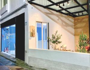 a white building with a door and a window at Backpackers' Hostel Taoyuan Airport in Dayuan