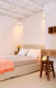 a bedroom with a bed and a wooden table at Kounelia Luxury Apartments in Kithnos
