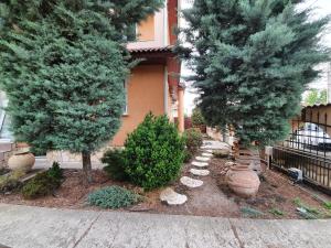 a garden area with a tree and shrubbery at Airport Luxury Apartman 42 in Vecsés
