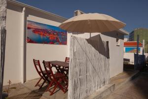 einen Tisch und Stühle unter einem Sonnenschirm auf einer Terrasse in der Unterkunft 137 Private family home -8 min from historic center in Vila Nova de Gaia